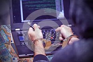 Criminal hacker hands locked in handcuffs. Closeup view