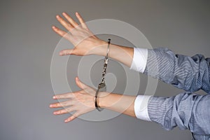 Criminal hands locked in handcuffs