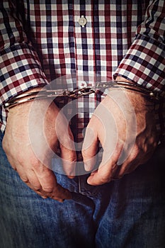 Criminal hands locked in handcuffs