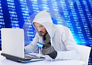 Criminal in hood on laptop with card in front of numbers