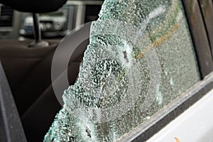 Criminal incident. Car burglary. Broken left side window of a car.