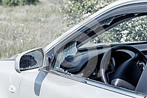 Criminal incident. Hacking a car. Broken driver`s side window of car. Thieves smashed window of car with fragments inside, glass