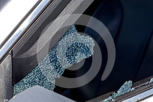 Criminal incident. Hacking a car. Broken driver`s side window of car. Thieves smashed window of car with fragments inside, glass