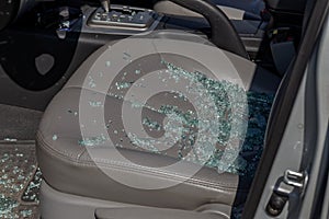 Criminal incident. Hacking a car. Broken driver`s side window of car. Thieves smashed window of car with fragments inside, glass