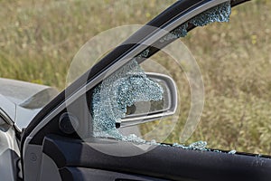 Criminal incident. Hacking a car. Broken driver`s side window of car. Thieves smashed window of car with fragments inside, glass