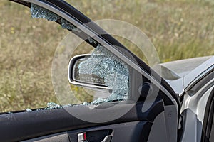 Criminal incident. Hacking a car. Broken driver`s side window of car. Thieves smashed window of car with fragments inside, glass