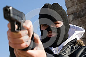 Criminal in mask aiming his target