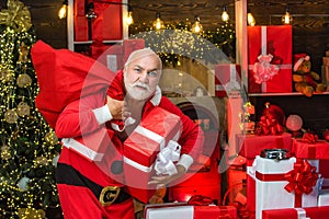 Criminal Santa Claus posing with a bag of christmas gifts. Criminal christmas. Funny bad Santa Claus with gift, bag with