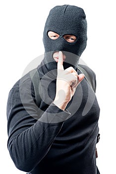 criminal shows his hand a finger near his lips asking