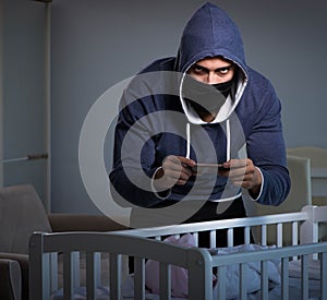 Criminal stealing baby in human child traficking concept