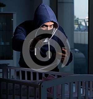 Criminal stealing baby in human child traficking concept