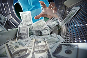 Criminal washing banknotes in machine, money laundering, financial fraud concept