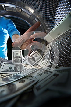 Criminal washing banknotes in machine, money laundering, financial fraud concept