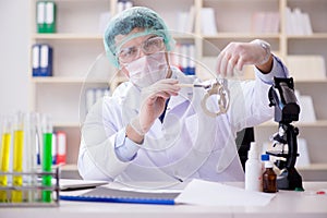 The criminologist police chemist looking at crime evidence