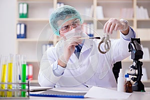 The criminologist police chemist looking at crime evidence