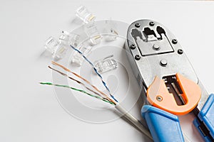 Crimper, connectors and ethernet cable on white background