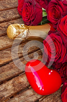 Crimson red roses with neck of champagne
