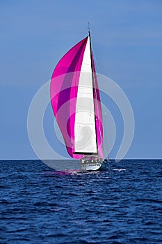 Crimson spinnaker sailing boat gray