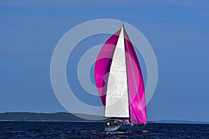 Crimson spinnaker sailing boat gray