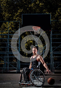 Cripple basketball player in a wheelchair plays on open gaming ground.