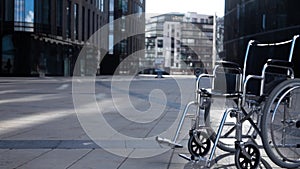 Cripple wheelchair rolling near modern building.