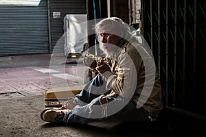 Crisis homeless aged man upset, stress no money sitting on sidewalk street, unemployed miserable street old man sad with broken