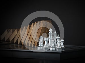 Crisis management, risk management, crisis solving or problem solving concept. Chess stopping wooden dominoes from collapsing on