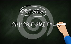 Crisis And opportunity Concept In Chalkboard with business man hand. Chalk Writing and hand written Text