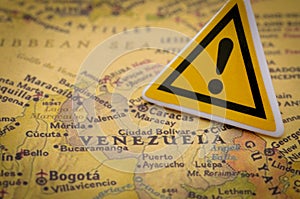 Crisis in Venezuela concept with caution sign placed over country map