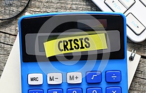 CRISIS word and a yellow sheet of paper on the calculator