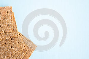 Crisp bread on the blue background. Corn dodger. Crackers. Loaf of bread
