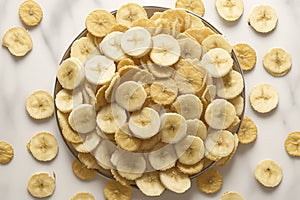 The crispness and lightness of banana chips by placing them on a clean, white marble background.