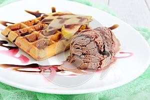 Crispy Belgian waffle with pieces of pear, berry and chocolate syrup and ice cream balls