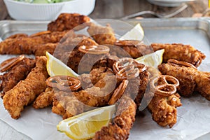 Breaded chicken breast with pretzel breading on a baking tray photo