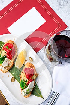 Crispy bruschetta with salmon, cheese, seaweed. Glass of red wine. Place for text