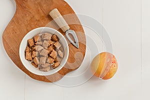 Crispy cereal and chocolate pillows with milk. brakefast with chocolate pillows and peach with knife on white andwooden background