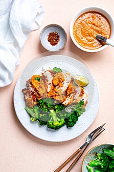 Crispy chicken cutlet with katsu sauce, with white rice and broccoli on a stone table.