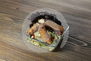 Crispy chicken salad with corn, cucumber, tomato, cabbage and lettuce leaf served in dish isolated on wooden table side view of