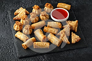 Crispy Chicken wontons, vegetable spring rolls and prawn toasts with sweet chilli sauce. chinese selection. fast food.