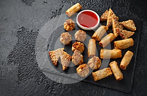 Crispy Chicken wontons, vegetable spring rolls and prawn toasts with sweet chilli sauce. chinese selection. fast food.