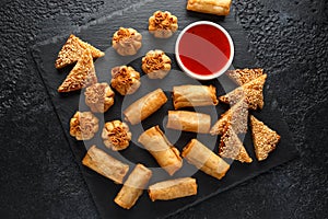 Crispy Chicken wontons, vegetable spring rolls and prawn toasts with sweet chilli sauce. chinese selection. fast food.