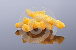 Crispy corn snacks on gray background