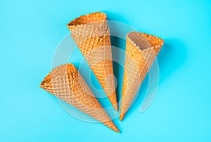 Crispy empty ice cream cones on a light blue background.