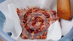 Crispy fried bacon rashers draining on plate with napkin