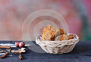 Crispy fried chicken in a basket on wooden table