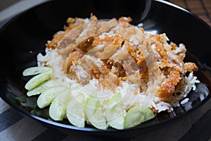 Crispy fried chicken with rice on a black plate