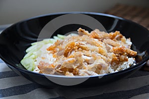 Crispy fried chicken with rice on a black plate