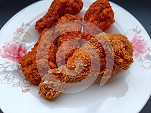 Crispy fried chicken wings on a plate, on black background., Close up