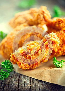 Crispy fried chicken wings on wooden table