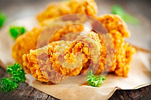 Crispy fried chicken wings on wooden table